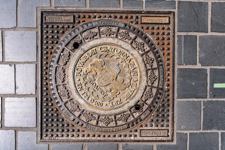 Verzierter Schachtdeckel mit dem Stadtwappen von Budapest