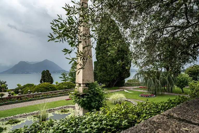 Garten mit Obelisk, weissem Pfau und Blick auf den Lago Maggiore