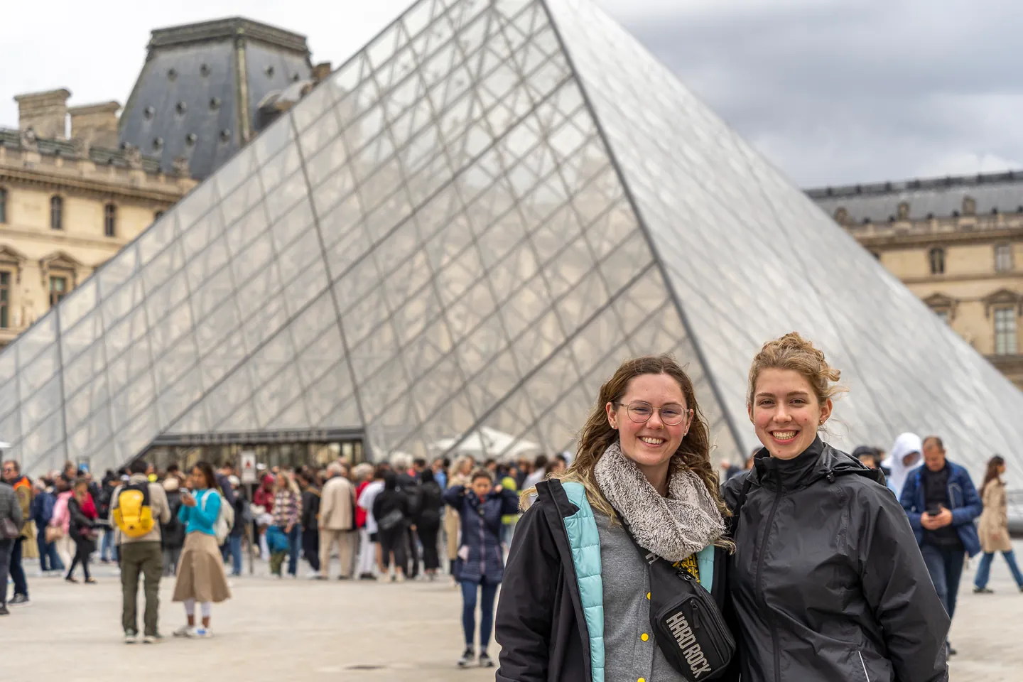 Zwei Teammitglieder vor der Glaspyramide des Louvre