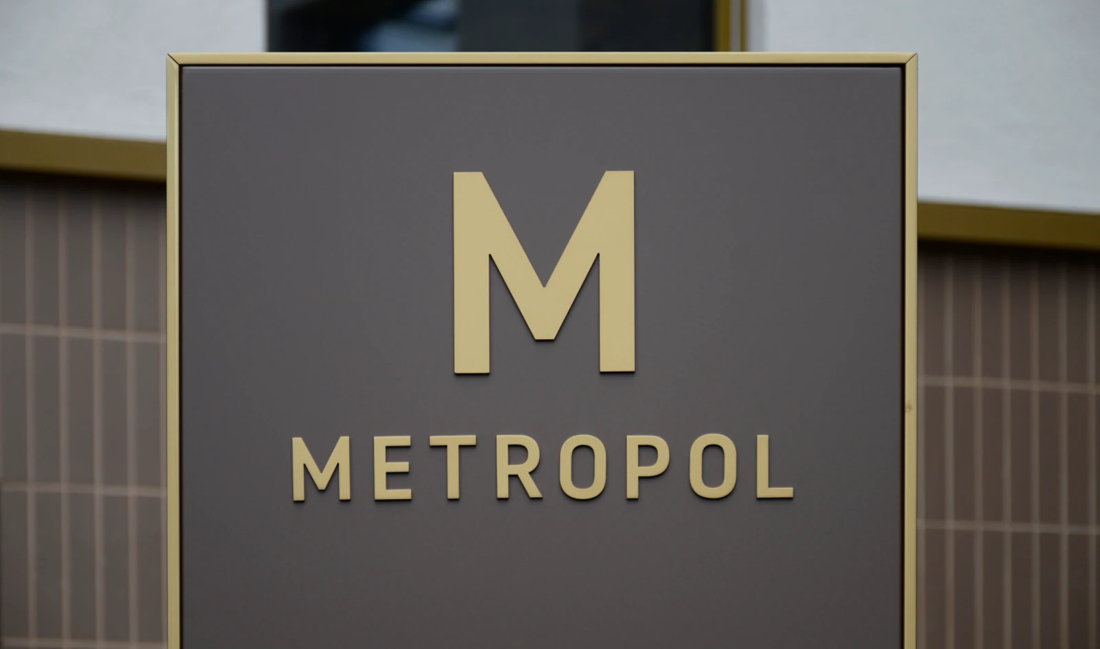 Metropol: goldene Wortmarke auf einem dunklen Schild